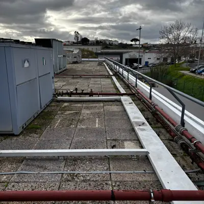 Vista do corredor da cobertura com a tubagem vermelha antiga ao longo do guarda-corpos